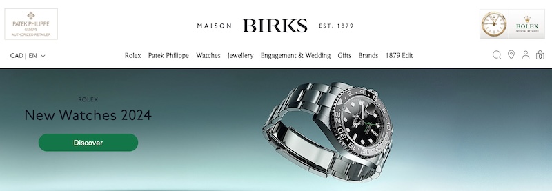 Maison Birks homepage featuring a sleek banner with the logo 'Maison Birks EST. 1879' at the top. The main focus is on a promotional graphic for 'New Watches 2024' by Rolex, showcasing a close-up of a sophisticated stainless steel Rolex watch with a black face and luminous markers. 