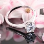 1.25 carat round diamond solitaire engagement ring surrounded by soft pink flowers.